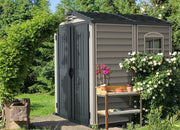 Duramax StoreMate Plus 6'x6' Vinyl Shed set in a lush garden, enhancing backyard storage with its elegant design and functional space.