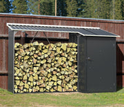 Duramax WoodStore 6'x3' firewood storage shed filled with stacked logs, set against a rustic wooden fence and forest backdrop, ideal for keeping wood dry and ready for use.