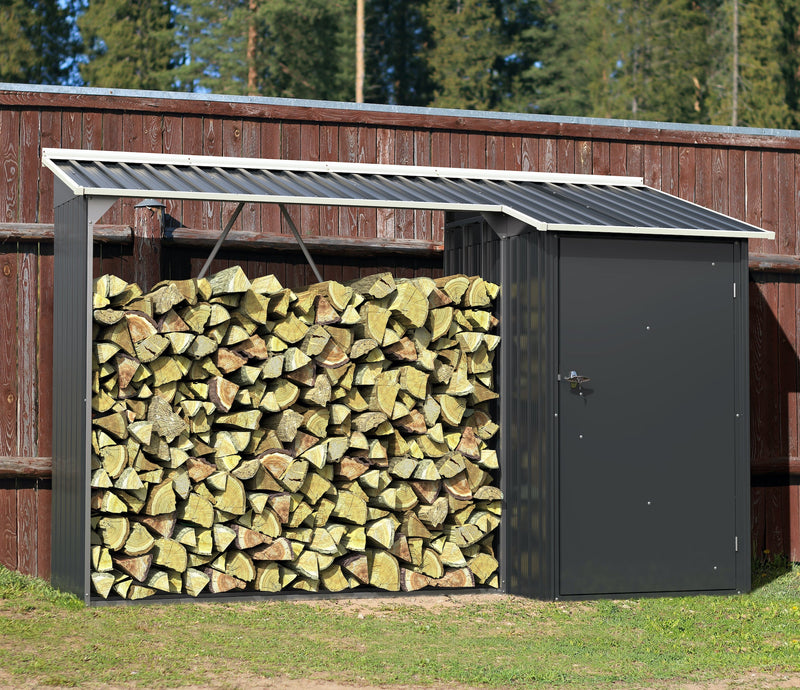 Duramax WoodStore 6'x3' firewood storage shed filled with stacked logs, set against a rustic wooden fence and forest backdrop, ideal for keeping wood dry and ready for use.
