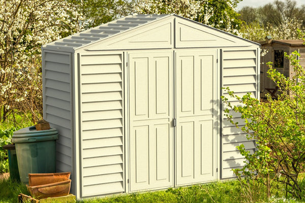 Duramax Sidepro 10.5'x3' shed placed in a serene garden setting with closed doors, highlighting its compact and durable design.