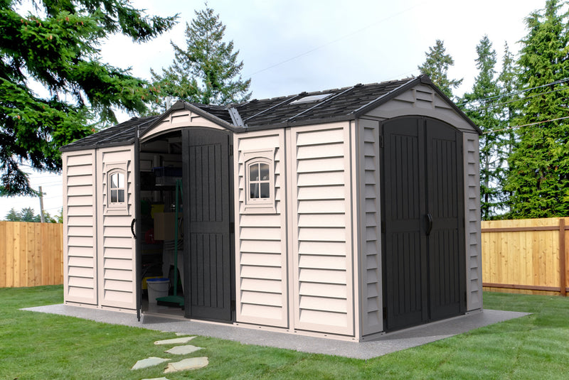 The Apex Pro 15'x8' Shed, open and full of tools and storage shelves, set in a lush green yard.