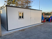Duramax Insulated Glass Building 13'x10' - 32003 installed on a concrete pad near traffic cones and utility equipment.