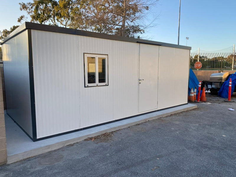 Duramax Insulated Glass Building 13'x10' - 32003 installed on a concrete pad near traffic cones and utility equipment.