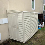 Duramax model 06625 SideMate Shed 4'x8' mounted on a wooden base beside a tan residential building.