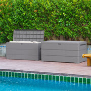 Two Duramax 71 Gallon Outdoor Storage Boxes in Gray, by the poolside with lush greenery in the background.