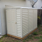 Side view of a Duramax SideMate Shed with Foundation 4'x8' (model 06625) placed beside a stucco house wall with a padlock on the door.

